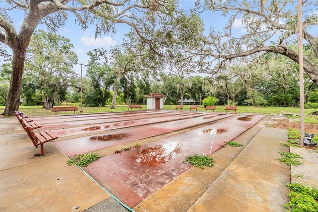 2699 Seville Blvd Unit 207, Clearwater, FL 33764 - view of property's community with shuffleboard and view of wooded area