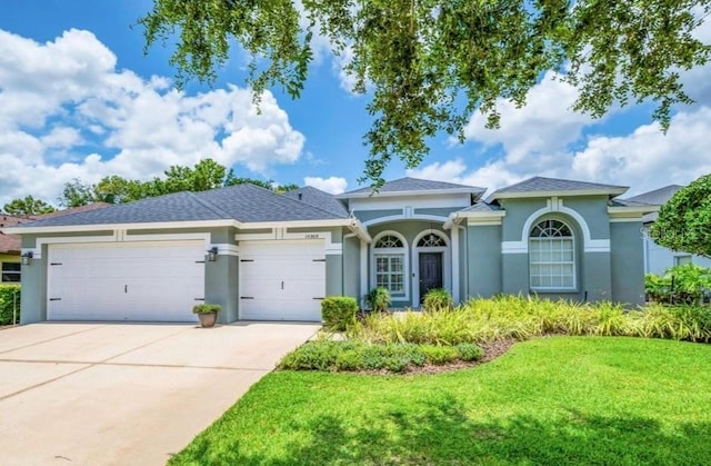 15309 Palomapark Ln, Lithia, FL 33547 - view of front of home with stucco siding, a garage, a front lawn, and driveway