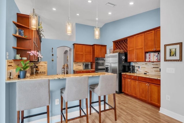 15309 Palomapark Ln, Lithia, FL 33547 - kitchen with open shelves, appliances with stainless steel finishes, arched walkways, tasteful backsplash, and recessed lighting