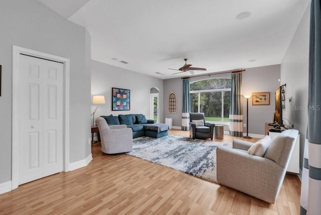 15309 Palomapark Ln, Lithia, FL 33547 - living room with arched walkways, light wood-type flooring, a ceiling fan, and baseboards