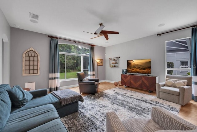 15309 Palomapark Ln, Lithia, FL 33547 - living area with wood finished floors, ceiling fan, arched walkways, and baseboards