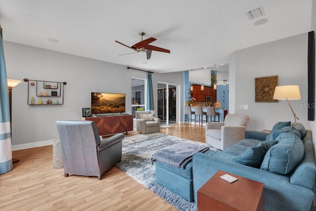 15309 Palomapark Ln, Lithia, FL 33547 - living area featuring light wood-style floors, a ceiling fan, and baseboards