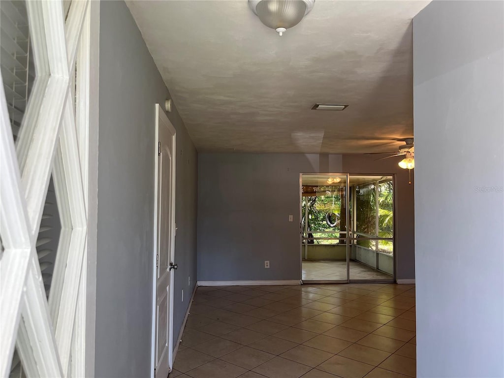 835 5th St, Port Orange, FL 32129 - tiled empty room with baseboards and a ceiling fan