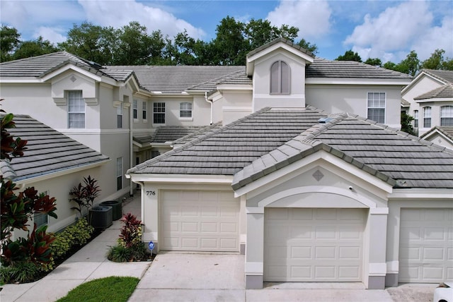 776 Grasslands Village Cir Unit 776, Lakeland, FL 33803 - multi unit property with stucco siding, a tile roof, concrete driveway, and a garage