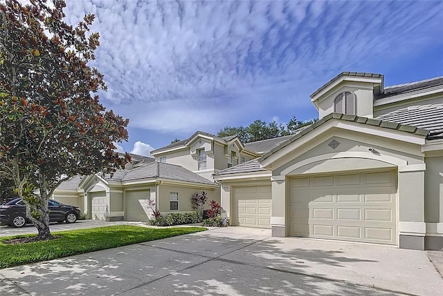776 Grasslands Village Cir Unit 776, Lakeland, FL 33803 - view of front of house featuring driveway, a tiled roof, a garage, and stucco siding