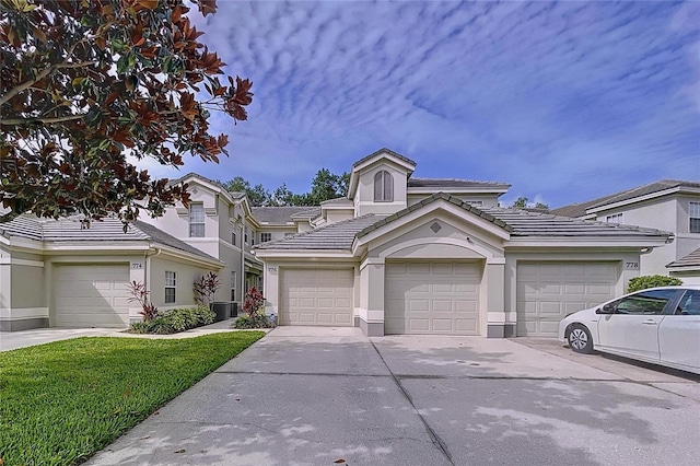 776 Grasslands Village Cir Unit 776, Lakeland, FL 33803 - view of front of house with a tiled roof, stucco siding, concrete driveway, and a front lawn