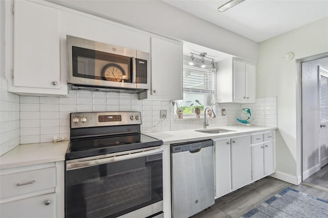 5728 14th Ave N Unit 101B, Saint Petersburg, FL 33710 - kitchen with stainless steel appliances, a sink, dark wood-style floors, and light countertops