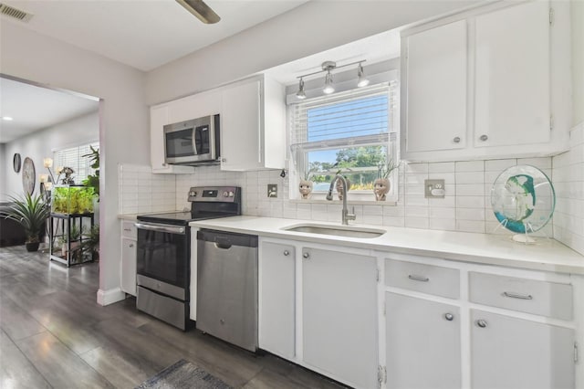 5728 14th Ave N Unit 101B, Saint Petersburg, FL 33710 - kitchen featuring stainless steel appliances, a sink, light countertops, white cabinets, and backsplash