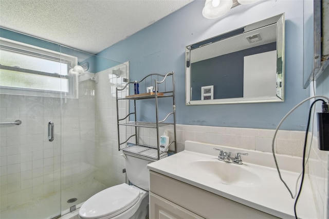 5728 14th Ave N Unit 101B, Saint Petersburg, FL 33710 - full bathroom with a stall shower, toilet, vanity, a textured ceiling, and tile walls