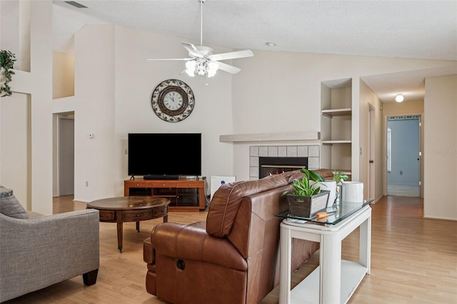 11638 Branch Mooring Dr, Tampa, FL 33635 - living area featuring a ceiling fan, light wood-style flooring, a tile fireplace, and high vaulted ceiling