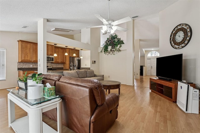 11638 Branch Mooring Dr, Tampa, FL 33635 - living room featuring ceiling fan, light wood-type flooring, a textured ceiling, and high vaulted ceiling