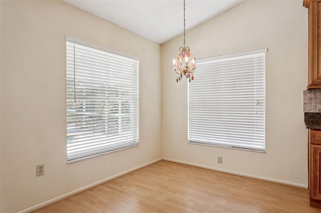 11638 Branch Mooring Dr, Tampa, FL 33635 - unfurnished dining area featuring a chandelier, light wood-type flooring, baseboards, and lofted ceiling