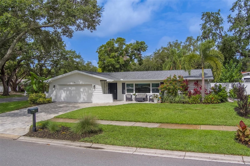1368 Whispering Pines Dr, Clearwater, FL 33764 - ranch-style house featuring an attached garage, decorative driveway, and a front yard