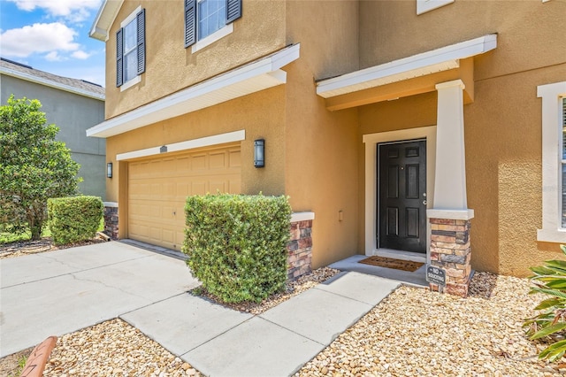 12244 Fairlawn Dr, Riverview, FL 33579 - doorway to property with an attached garage, stucco siding, stone siding, and concrete driveway