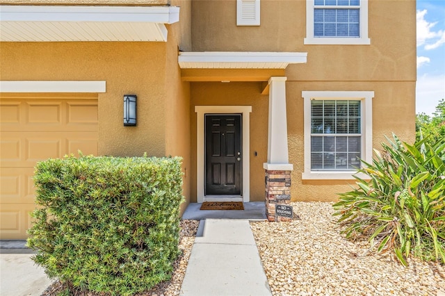 12244 Fairlawn Dr, Riverview, FL 33579 - view of exterior entry with stucco siding and an attached garage