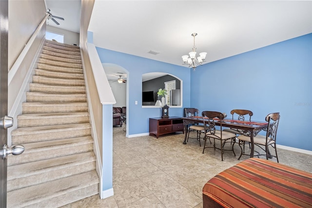 12244 Fairlawn Dr, Riverview, FL 33579 - dining area featuring a chandelier, stairway, a ceiling fan, arched walkways, and tile patterned floors