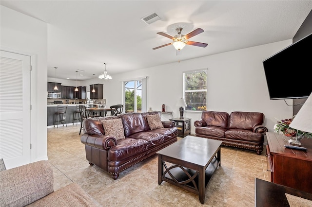 12244 Fairlawn Dr, Riverview, FL 33579 - living area with light tile patterned flooring, a ceiling fan, and a chandelier