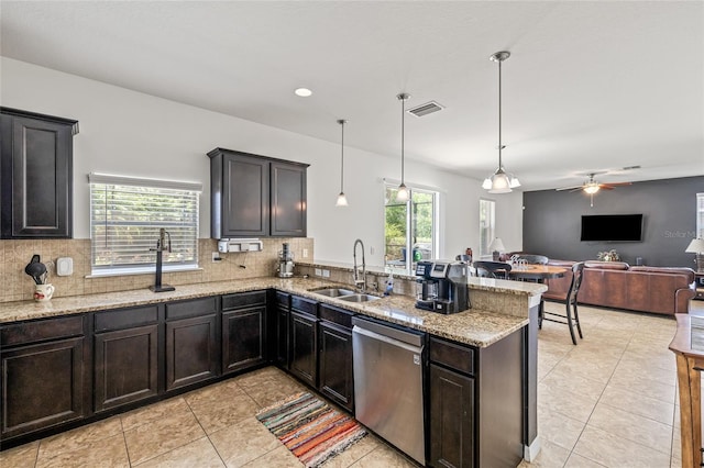12244 Fairlawn Dr, Riverview, FL 33579 - kitchen with stainless steel dishwasher, a peninsula, tasteful backsplash, and light stone counters