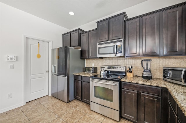 12244 Fairlawn Dr, Riverview, FL 33579 - kitchen with stainless steel appliances, decorative backsplash, light tile patterned flooring, light stone counters, and recessed lighting