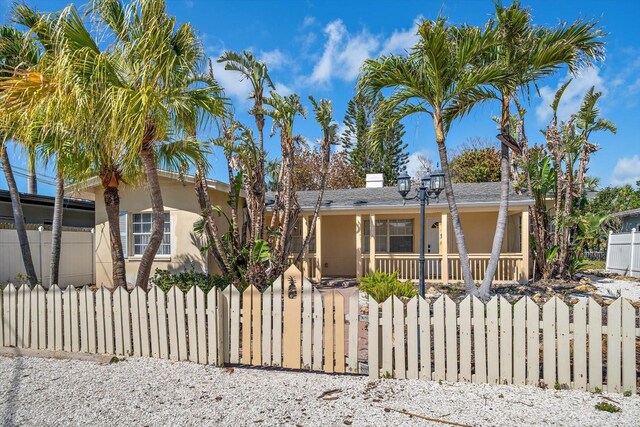 608 Bay Esplanade, Clearwater Beach, FL 33767 - view of front of house with a fenced front yard, stucco siding, and a porch