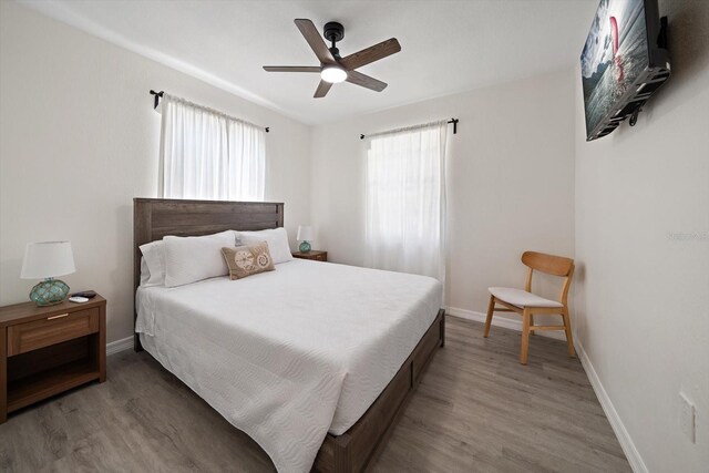 608 Bay Esplanade, Clearwater Beach, FL 33767 - bedroom with multiple windows, wood finished floors, and a ceiling fan