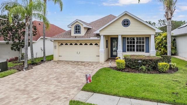 4400 English Turn Way, Wesley Chapel, FL 33543 - view of front of house featuring decorative driveway, a garage, a front lawn, a shingled roof, and stucco siding