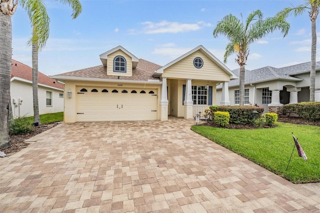 4400 English Turn Way, Wesley Chapel, FL 33543 - view of front of home featuring decorative driveway, stucco siding, a front lawn, and a garage