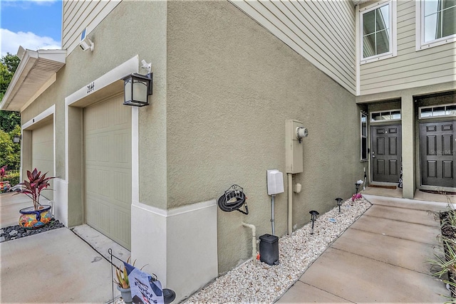 2844 Jacob Crossing Ln, Holiday, FL 34691 - view of exterior entry with stucco siding and an attached garage