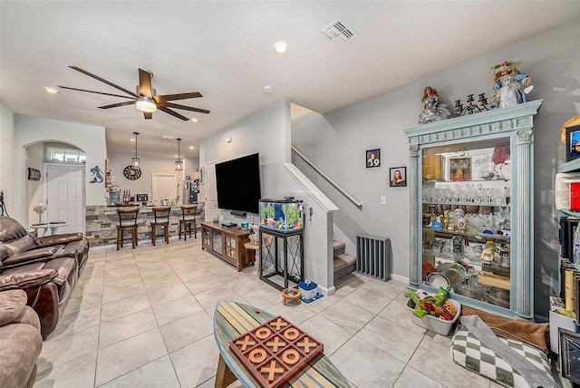 2844 Jacob Crossing Ln, Holiday, FL 34691 - living room with ceiling fan, arched walkways, stairs, and light tile patterned floors