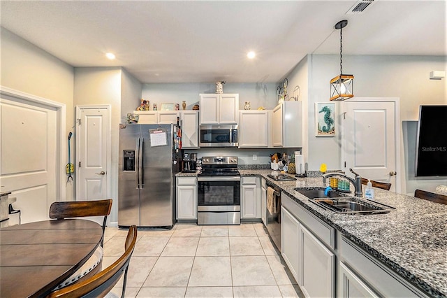 2844 Jacob Crossing Ln, Holiday, FL 34691 - kitchen featuring appliances with stainless steel finishes, a sink, dark stone counters, light tile patterned floors, and recessed lighting