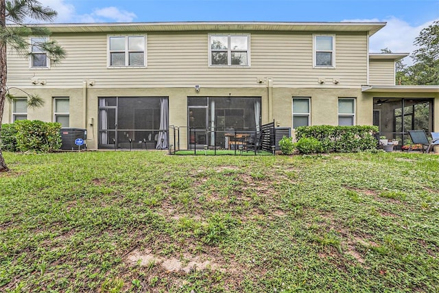 2844 Jacob Crossing Ln, Holiday, FL 34691 - rear view of property featuring a sunroom, a lawn, stucco siding, and cooling unit