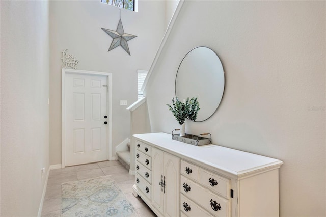 14716 Crescent Rock Dr, Wimauma, FL 33598 - entryway featuring stairway, light tile patterned floors, baseboards, and a towering ceiling
