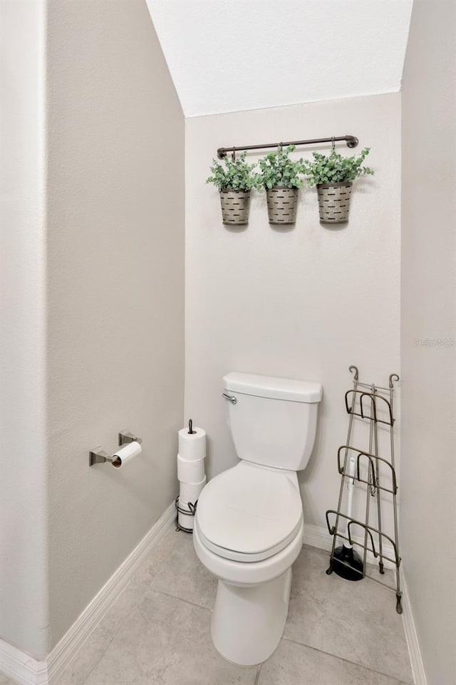 14716 Crescent Rock Dr, Wimauma, FL 33598 - bathroom featuring toilet, tile patterned floors, baseboards, and vaulted ceiling