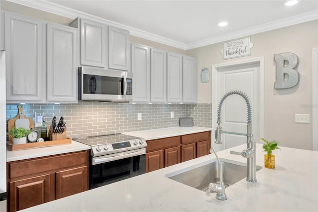 14716 Crescent Rock Dr, Wimauma, FL 33598 - kitchen featuring appliances with stainless steel finishes, a sink, light countertops, tasteful backsplash, and ornamental molding