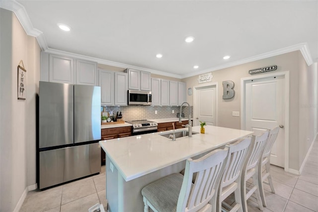 14716 Crescent Rock Dr, Wimauma, FL 33598 - kitchen with appliances with stainless steel finishes, a sink, light tile patterned floors, gray cabinetry, and ornamental molding