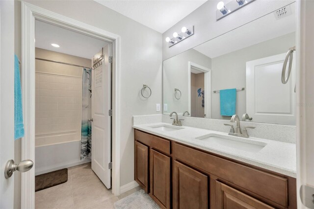 14716 Crescent Rock Dr, Wimauma, FL 33598 - full bathroom featuring double vanity, shower / bath combo with shower curtain, tile patterned flooring, and baseboards