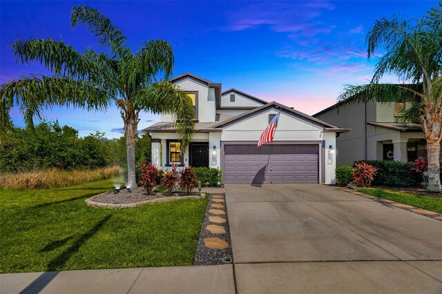 14716 Crescent Rock Dr, Wimauma, FL 33598 - traditional home with stucco siding, an attached garage, a front lawn, and driveway