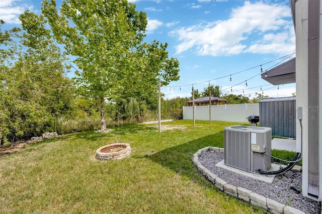 14716 Crescent Rock Dr, Wimauma, FL 33598 - view of yard featuring central AC unit and an outdoor fire pit