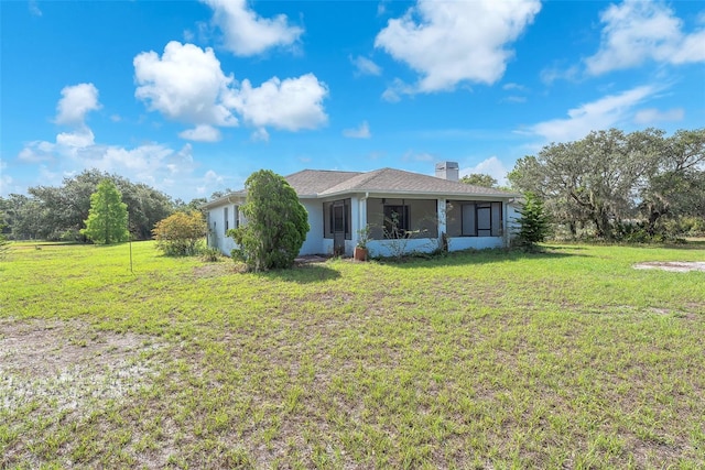 17023 Alderman Turner Rd, Wimauma, FL 33598 - view of front of property with a chimney, a front lawn, a sunroom, and stucco siding