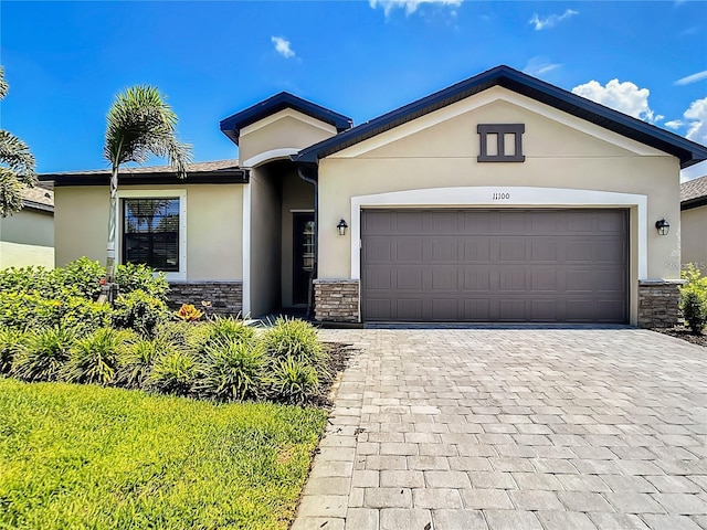 11100 Balfour St, Venice, FL 34293 - ranch-style home featuring stone siding, decorative driveway, and stucco siding