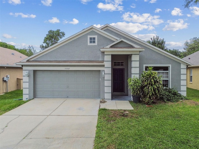 15709 Leatherleaf Ln, Land O Lakes, FL 34638 - view of front of house featuring a front lawn, driveway, a garage, and stucco siding