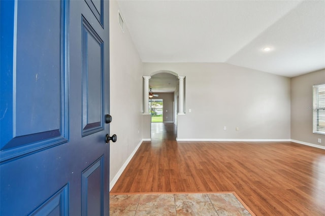 15709 Leatherleaf Ln, Land O Lakes, FL 34638 - foyer entrance with decorative columns, light wood-style floors, arched walkways, baseboards, and vaulted ceiling