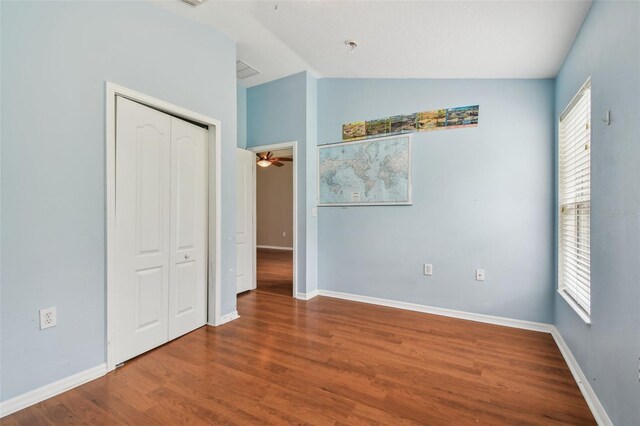 15709 Leatherleaf Ln, Land O Lakes, FL 34638 - unfurnished bedroom with lofted ceiling, wood finished floors, baseboards, and a closet