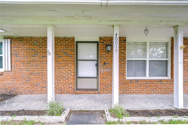 40019 Pretty Redbird Rd, Zephyrhills, FL 33540 - view of exterior entry with brick siding and a porch