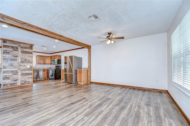 40019 Pretty Redbird Rd, Zephyrhills, FL 33540 - unfurnished living room with a ceiling fan, light wood-type flooring, baseboards, beam ceiling, and a textured ceiling