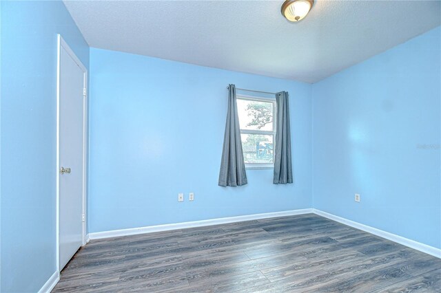 40019 Pretty Redbird Rd, Zephyrhills, FL 33540 - unfurnished room featuring dark wood-style flooring, baseboards, and a textured ceiling