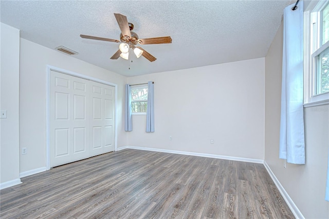 40019 Pretty Redbird Rd, Zephyrhills, FL 33540 - unfurnished bedroom featuring wood finished floors, a textured ceiling, a closet, baseboards, and a ceiling fan
