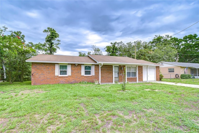 40019 Pretty Redbird Rd, Zephyrhills, FL 33540 - ranch-style house with brick siding, a front yard, driveway, and a garage