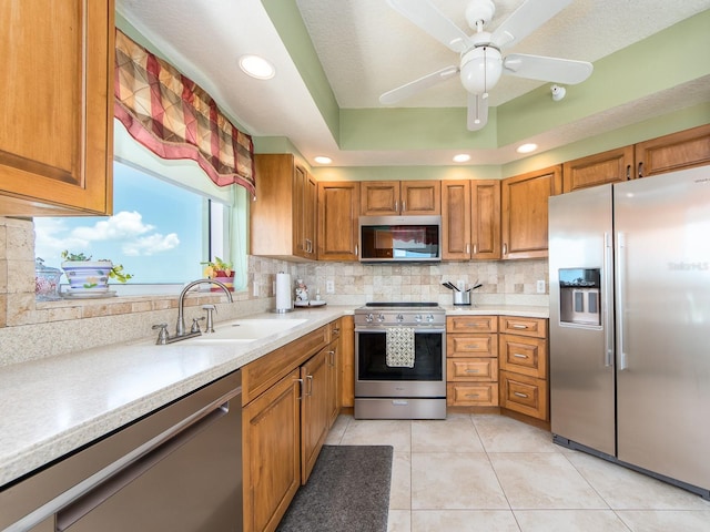 1170 Gulf Blvd Unit 1006, Clearwater Beach, FL 33767 - kitchen featuring appliances with stainless steel finishes, brown cabinetry, a sink, backsplash, and light countertops