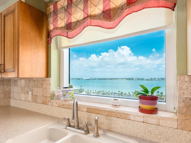 1170 Gulf Blvd Unit 1006, Clearwater Beach, FL 33767 - kitchen with brown cabinets, light countertops, decorative backsplash, and a water view